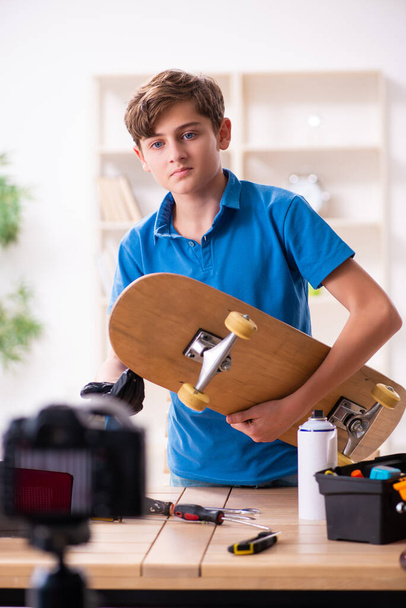 Хлопчик ремонтує скейтборд і записує відео для свого блогу
 - Фото, зображення