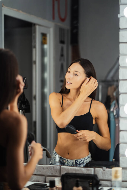 Reflection of young beautiful woman applying her make-up - Foto, imagen