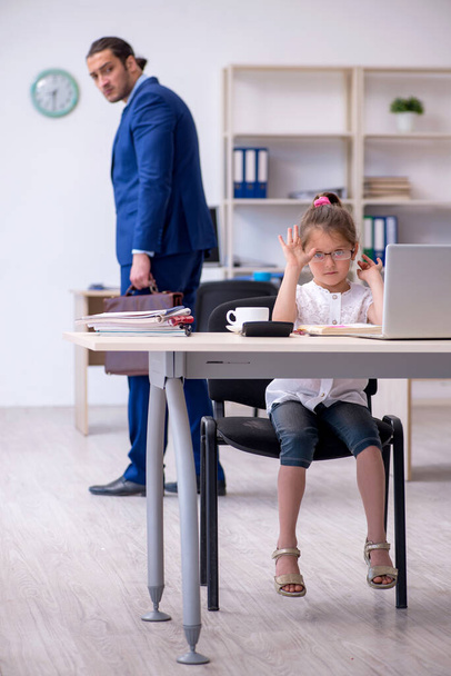 Молодой работник и его маленькая девочка в офисе - Фото, изображение