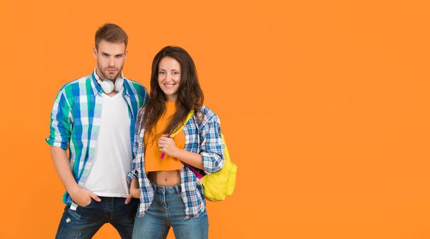 Romantic couple of serious handsome man and happy pretty woman in casual fashion style orange background, love, copy space - Фото, изображение