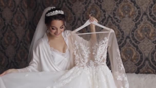Braut in Dessous dreht sich im Tanz mit ihrem Hochzeitskleid. Weißes Boudoir-Kleid und Schleier - Filmmaterial, Video