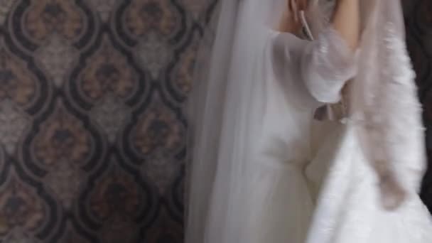 Nevěsta ve spodním prádle se točí v tanci se svými svatebními šaty. Bílé budoárové šaty a závoj - Záběry, video