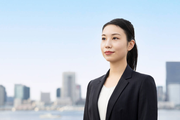 Азиатская молодая деловая женщина и городской пейзаж Токио в прекрасный день - Фото, изображение