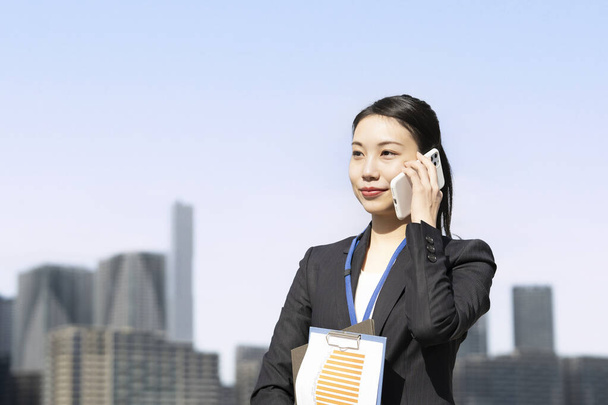 Uma mulher de negócios que fala com seu smartphone no ouvido - Foto, Imagem