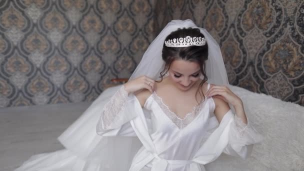 Noiva em vestido boudoir branco, véu e em um manto de seda. Preparativos da manhã de casamento antes da cerimônia - Filmagem, Vídeo