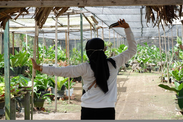 A hidzsábot viselő fiatal ázsiai nők boldogan sétálnak be a virágoskertbe egy természetjáráson a világjárvány idején. - Fotó, kép