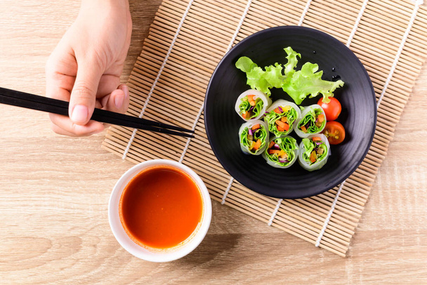 Colorful fresh vegetables salad spring roll eating with chili sauce, Healthy vegan food - Foto, afbeelding
