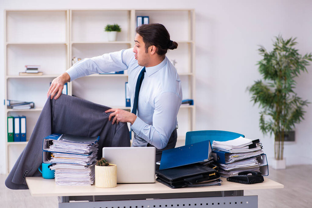 Jovem funcionário do sexo masculino infeliz com trabalho excessivo - Foto, Imagem