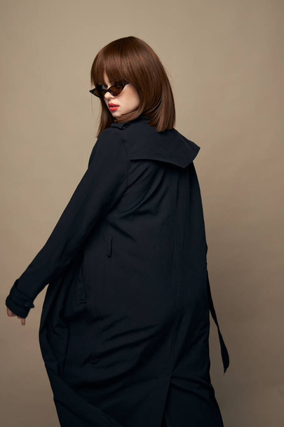 Beautiful brunette classic coat attractive appearance rejoicing on an isolated background  - Foto, Bild
