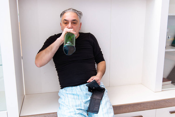 Старик пьет вино в спальне - Фото, изображение