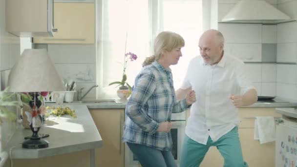 Mature Couple Dancing In The Kitchen. - Materiał filmowy, wideo