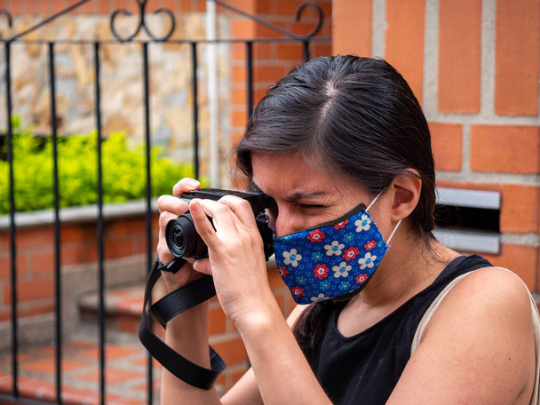 Jovem mulher hispânica tira uma foto com uma câmera - Foto, Imagem