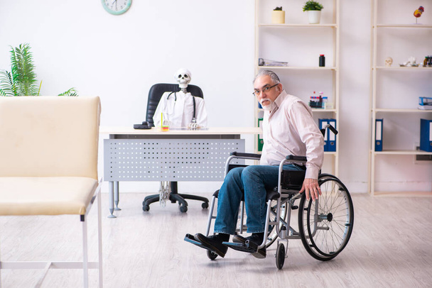 Старик в инвалидной коляске навещает мёртвого доктора - Фото, изображение
