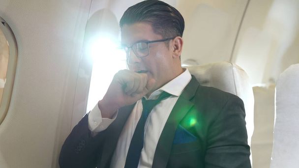 Un hombre de negocios soñoliento viaja en un viaje de negocios en avión - Foto, Imagen