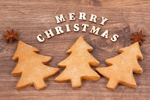 Inscription Merry Christmas with fresh homemade gingerbreads and cookies for festive time - Foto, Imagem