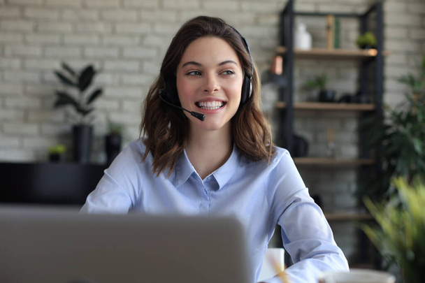Female customer support operator with headset and smiling - Photo, Image