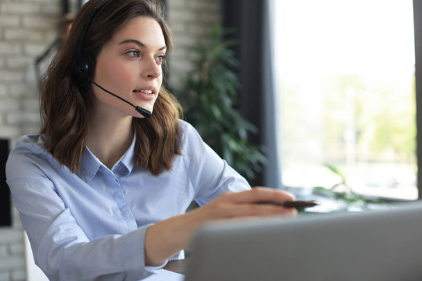 Freelance operator talking with headsets and consulting clients from home office - 写真・画像
