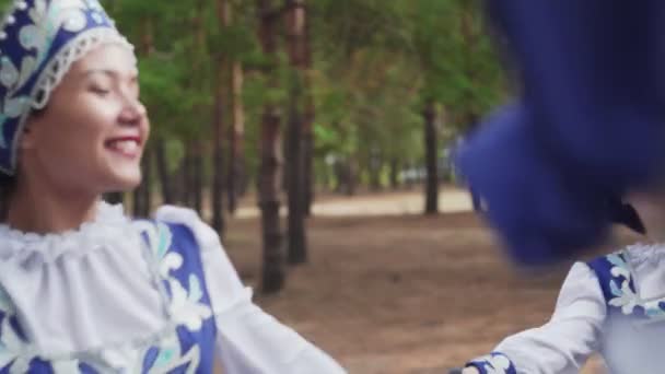 Acercamiento de seis mujeres jóvenes en trajes populares tradicionales rusos están bailando en el bosque de verano - Imágenes, Vídeo