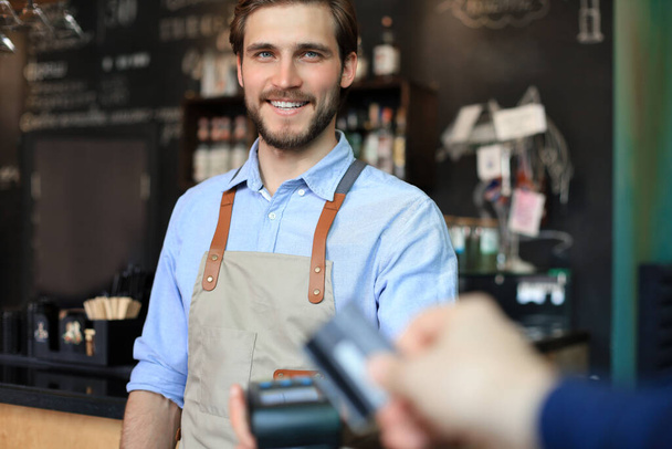 Customer using credit card for payment to owner at cafe restaurant, cashless technology - Fotoğraf, Görsel