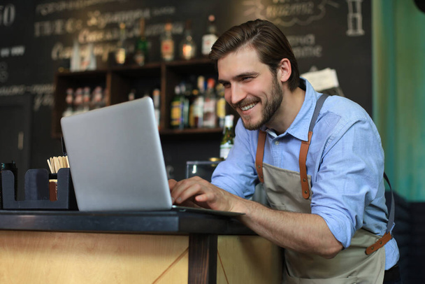 Restaurant manager working on laptop, counting profit - Foto, Imagen