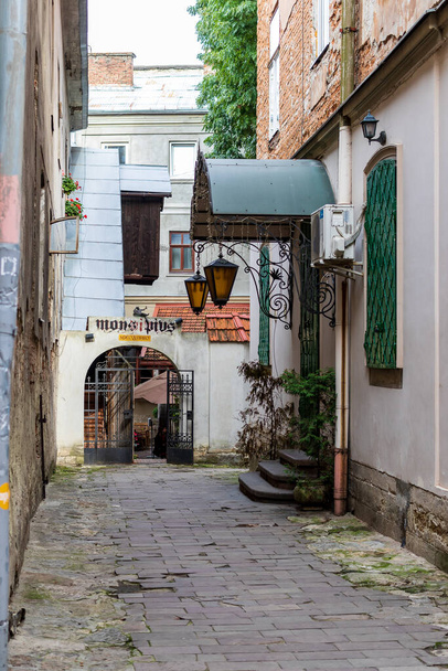 Lviv, Ukraine - October 24, 2020: A narrow cobblestone street with a path in the historic center of Lviv. Street scene. Streets and architecture of the old city. - Foto, afbeelding