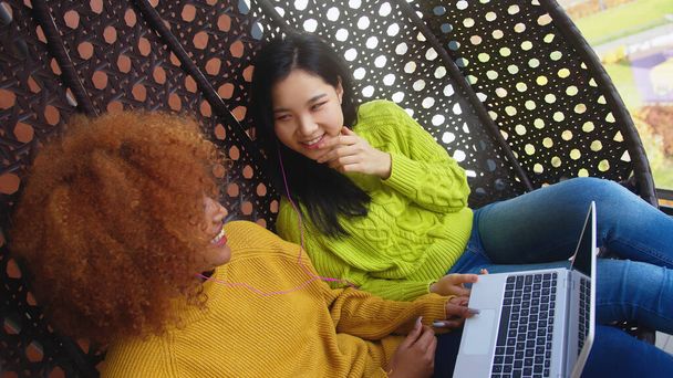 Deux jeunes femmes bavardant et naviguant sur les réseaux sociaux. L'amitié multiraciale - Photo, image