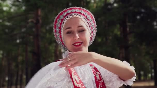 Крупным планом девушки танцуют красные русские традиционные танцы в летнем лесу - Кадры, видео