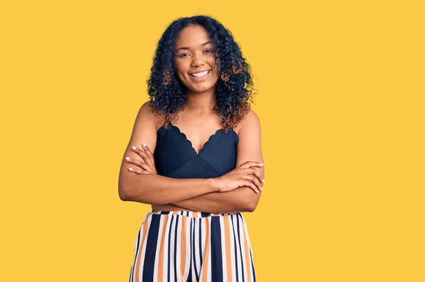 Young african american woman wearing casual clothes happy face smiling with crossed arms looking at the camera. positive person.  - Photo, Image