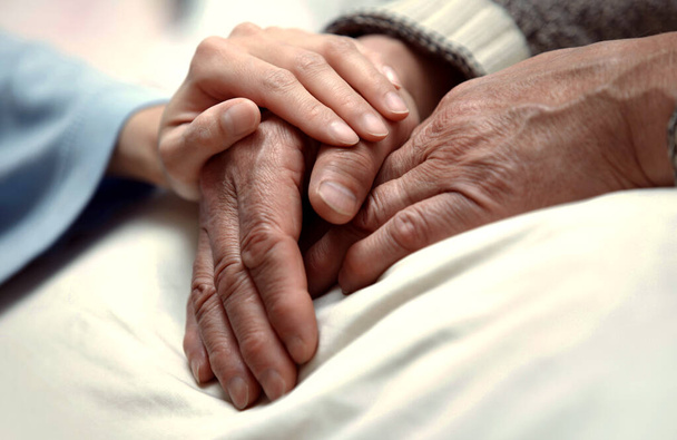 Hand von Frau berührt Seniorin in Klinik - Foto, Bild