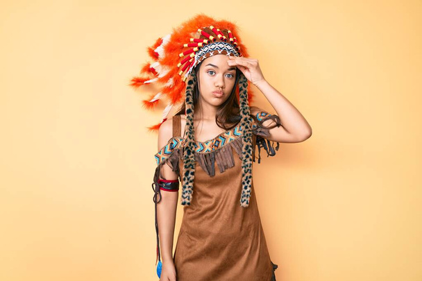 Jeune belle fille latine portant costume indien inquiet et stressé par un problème avec la main sur le front, nerveux et anxieux pour la crise  - Photo, image