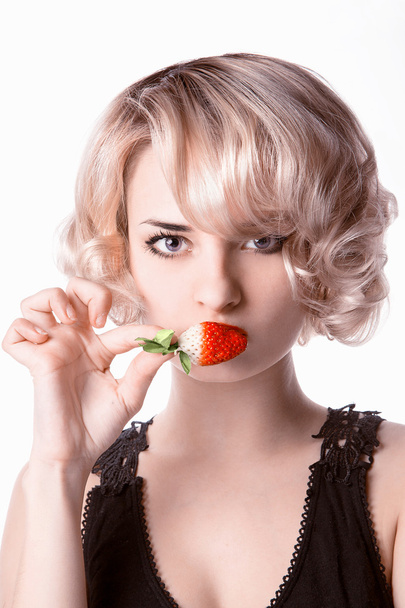 Woman eating a strawberry - Φωτογραφία, εικόνα