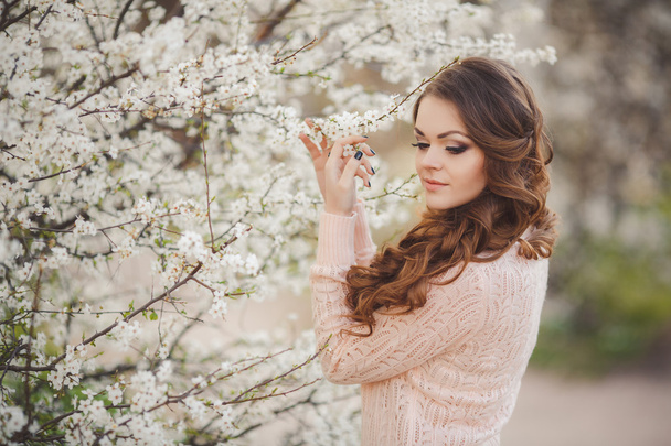 Portrait of young brunette in the spring blooming garden - Foto, afbeelding