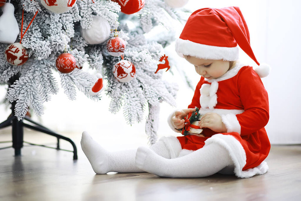Merry bright christmas. Lovely baby enjoy christmas. Childhood memories. Santa girl little child celebrate christmas at home. Family holiday. Girl cute child cheerful mood play near christmas tree. - Photo, Image