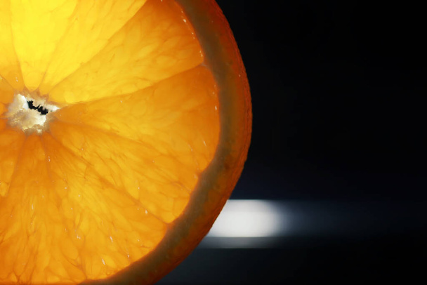 Složení s pomerančovými a grapefruitovými plátky na černém pozadí. Kousek pomeranče na černém pozadí s kapkami vody. Šťavnatý pomeranč na stole. - Fotografie, Obrázek