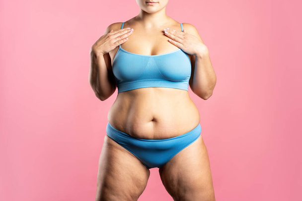 Fat woman in blue underwear on pink background, overweight female body, studio shot - Фото, зображення