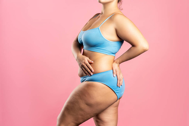 Fat woman in blue underwear on pink background, overweight female body, studio shot with copy space - Foto, Imagem