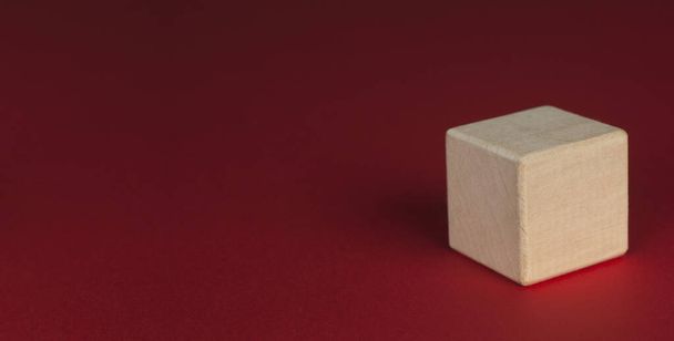 Wooden cube on a red background. - Photo, Image