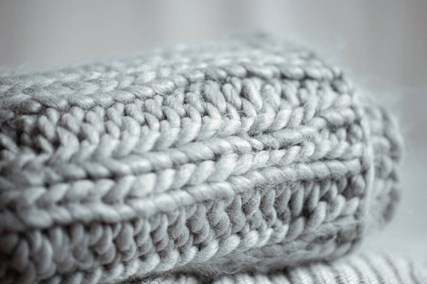 Gros plan d'articles tricotés soigneusement pliés de couleur grise sur un fond clair. - Photo, image