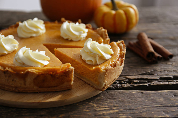 Traditional thanksgiving food on wooden table. Orange delicious homemade pumpkin pie with crust and decorative items. Thanksgiving table setting concept.Top view, close up, copy space, background. - Zdjęcie, obraz