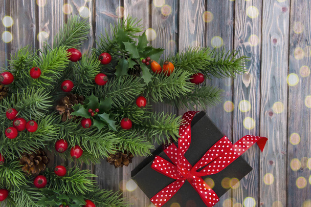 木製のテーブルの上にクリスマスツリー、コーン、赤い果実や贈り物の装飾枝。クリスマスの装飾. - 写真・画像