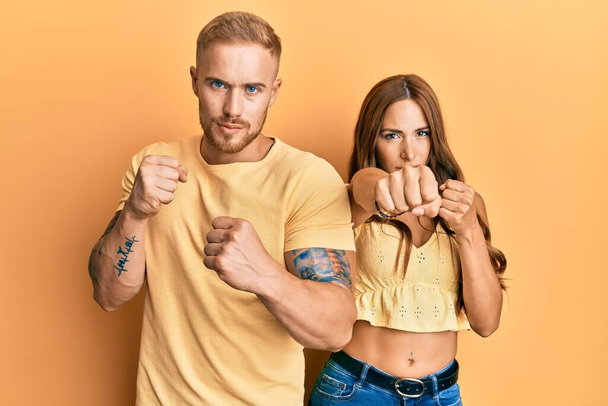 Young couple of girlfriend and boyfriend hugging and standing together punching fist to fight, aggressive and angry attack, threat and violence  - Valokuva, kuva