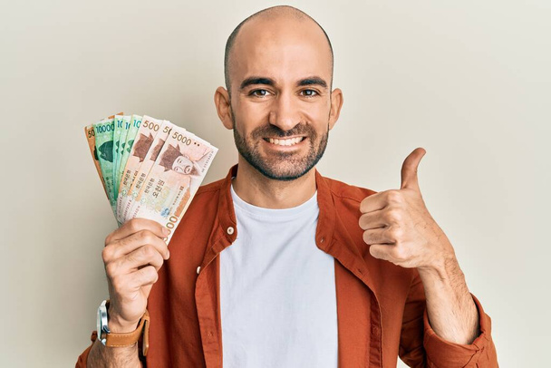 A dél-koreait fogva tartó spanyol kopasz férfi boldogan mosolygó bankjegyeket nyert kézen és ujjal mutogatva.  - Fotó, kép