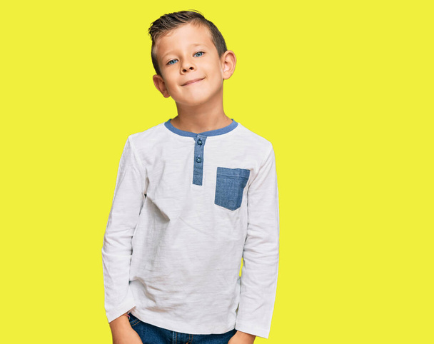 Adorable enfant caucasien portant des vêtements décontractés détendus avec une expression sérieuse sur le visage. simple et naturel regardant la caméra.  - Photo, image