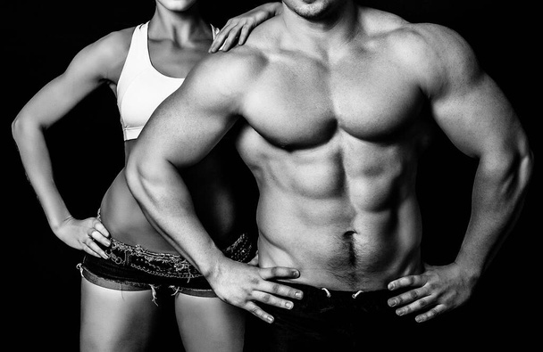 Δυνατή γυναίκα και άντρας σε μαύρο φόντο - Φωτογραφία, εικόνα