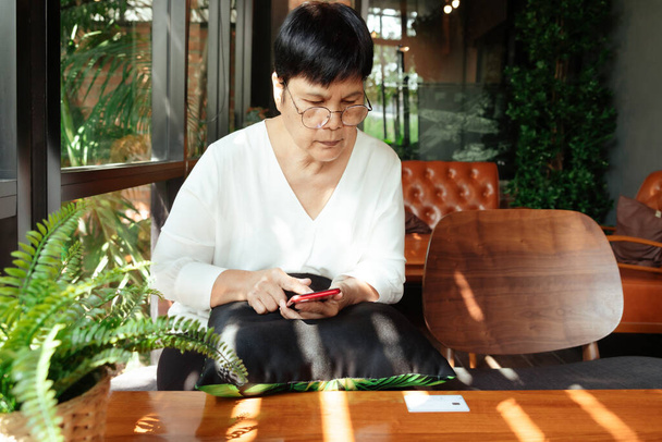 Cyber Monday Sale Concept, Senior woman make payment for online shopping on smartphone - Fotó, kép