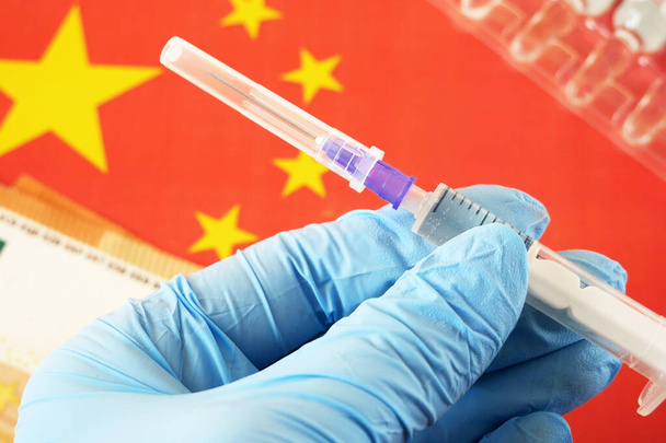 Kína zászló, fecskendők koronavírus vakcinával és europénzzel, pénz a vakcina beszerzésére és gyártására, kínai vakcinák importálása közelkép - Fotó, kép