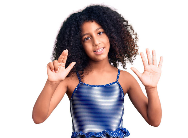 African american child with curly hair wearing swimwear showing and pointing up with fingers number eight while smiling confident and happy.  - Foto, imagen