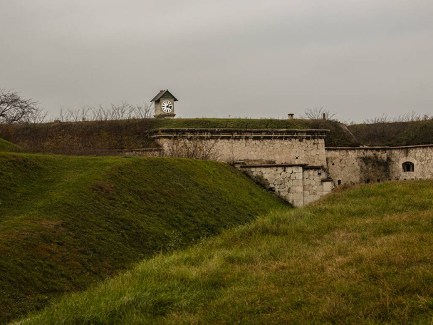 Historiallinen linnoitus piilossa kellotorni keskuudessa vihreät kukkulat - Valokuva, kuva