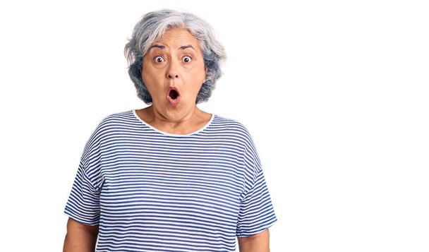 Senior woman with gray hair wearing casual striped clothes afraid and shocked with surprise expression, fear and excited face.  - Foto, imagen