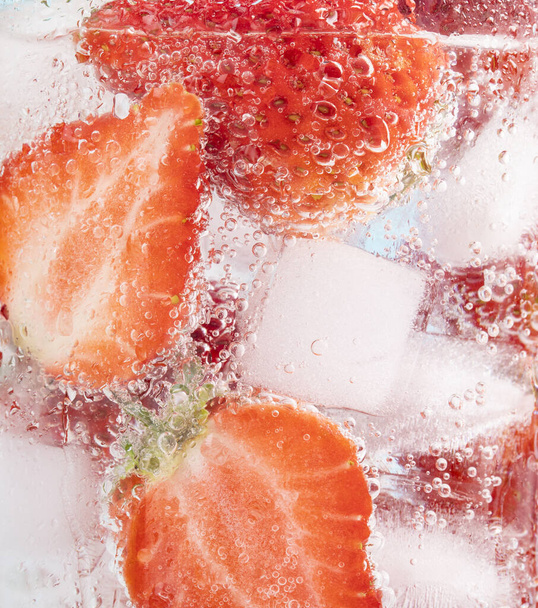 A closeup shot of strawberry slices in a glass of cold drink - Fotoğraf, Görsel